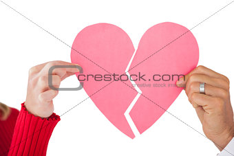 Couple holding two halves of broken heart