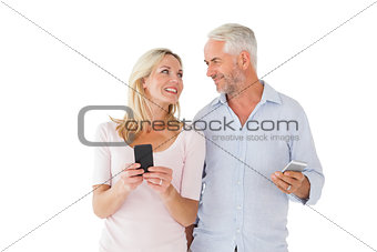 Happy couple texting on their smartphones