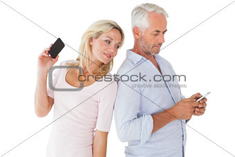 Happy couple texting on their smartphones