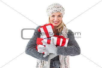 Smiling woman in winter fashion holding presents