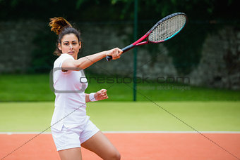 Young tennis player hitting ball
