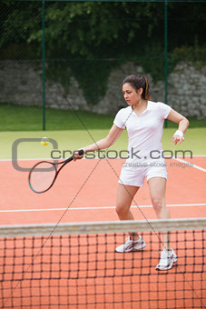 Pretty tennis player hitting ball