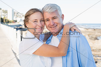 Happy casual couple hugging by the coast
