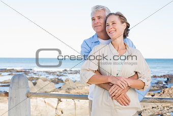 Happy casual couple hugging by the coast