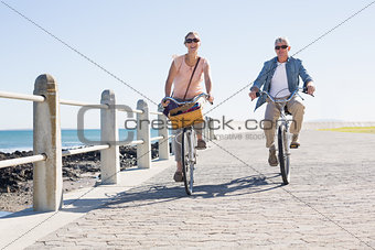 Happy casual couple going for a bike ride on the pier