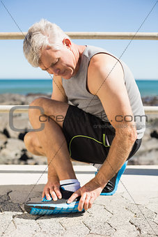 Fit man gripping his injured ankle