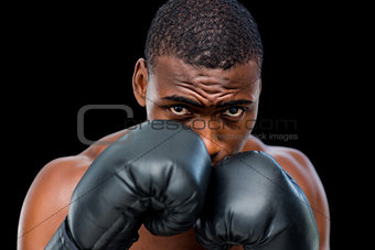 Portrait of a shirtless muscular boxer in defensive stance