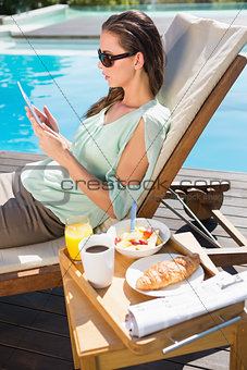 Woman using digital tablet with breakfast on table