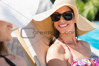 Women wearing hats by swimming pool