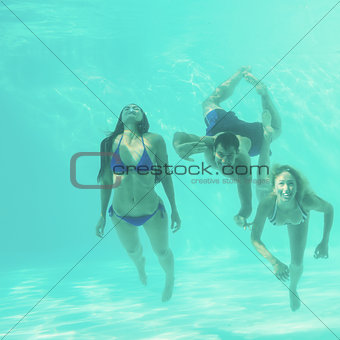 Friends underwater in swimming pool
