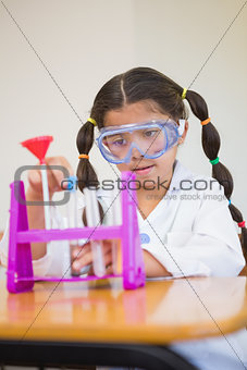 Cute pupil dressed up as scientist in classroom