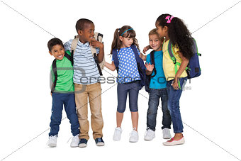 Cute schoolchildren smiling at camera and wearing backpacks