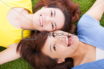 two asian pleasure young woman lying on grass