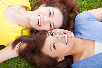two  pleasure young woman lying on grassland
