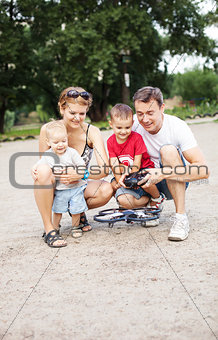 Young family with two boys playing with RC quadrocopter toy