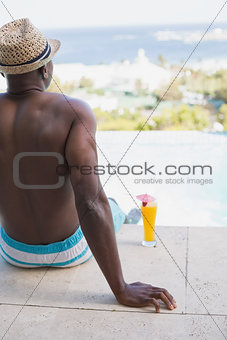 Man in swimming trunks relaxing poolside