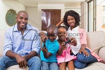 Happy family relaxing on the couch playing video games