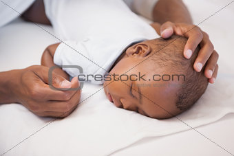 Baby boy sleeping peacefully on couch with father