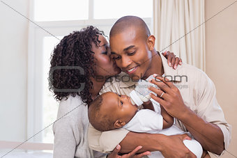 Happy parents feeding their baby boy a bottle