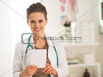 Happy doctor woman using tablet pc in office