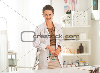 Portrait of doctor woman holding stethoscope in office