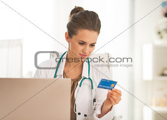 Doctor woman with credit card making online shopping