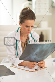 Doctor woman looking on fluorography in office