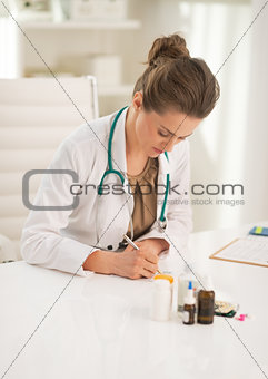 Doctor woman writing in prescription