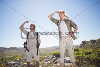 Hiking couple standing on mountain terrain looking around