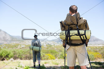 Happy hiking couple walking on mountain trail