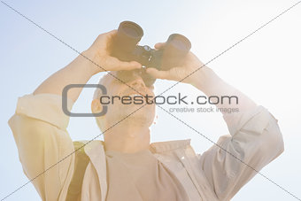 Happy hiker looking through binoculars