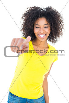 Pretty girl in yellow tshirt and denim hot pants smiling at camera