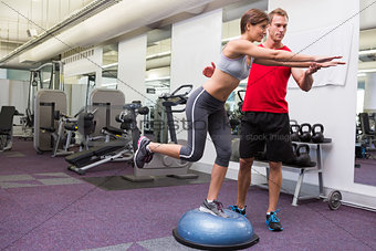 Personal trainer with client on bosu ball
