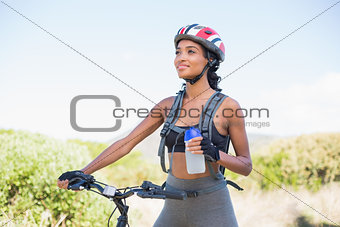 Fit woman going for bike ride holding water bottle