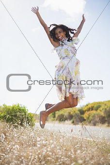 Happy pretty woman jumping up in floral dress