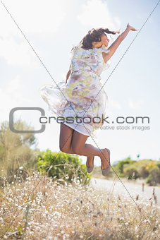 Beautiful woman in floral dress jumping up