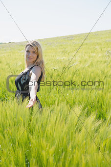 Pretty blonde in sundress standing in wheat field