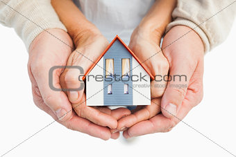 Couple holding small model house in hands
