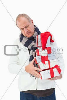 Mature man in winter clothes holding gifts