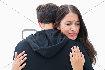 Unhappy brunette hugging her boyfriend