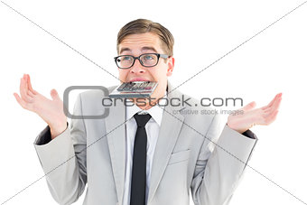 Geeky shrugging businessman biting calculator
