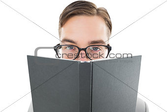 Geeky man looking over book