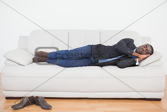 Tired businessman sleeping on sofa