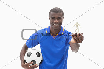 Football player in blue holding ball and figurine