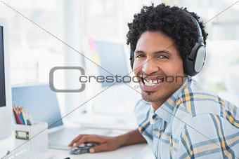 Young designer listening to music as he works