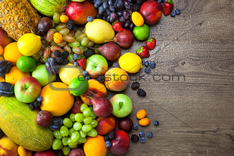 Mix of Fresh Fruits  with water drops on dark wooden table