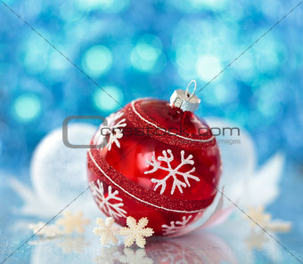 Red ball with snowflake against de-focused blue lights.