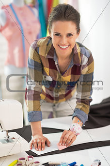 Portrait of smiling tailor woman working with fabric