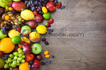 Different Organic Fruits  with  water drops on wooden table back