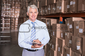 Warehouse manager writing on clipboard